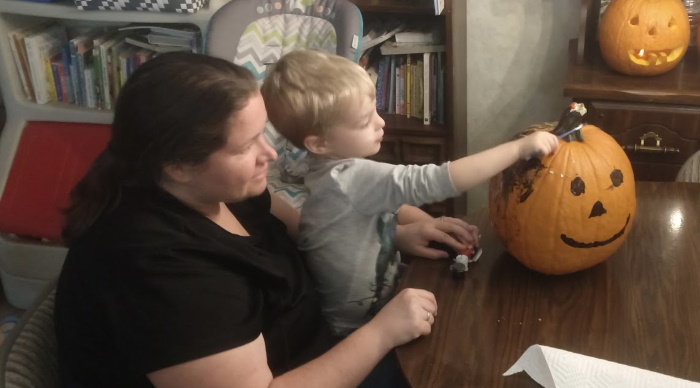 My son and wife painting a pumpkin.